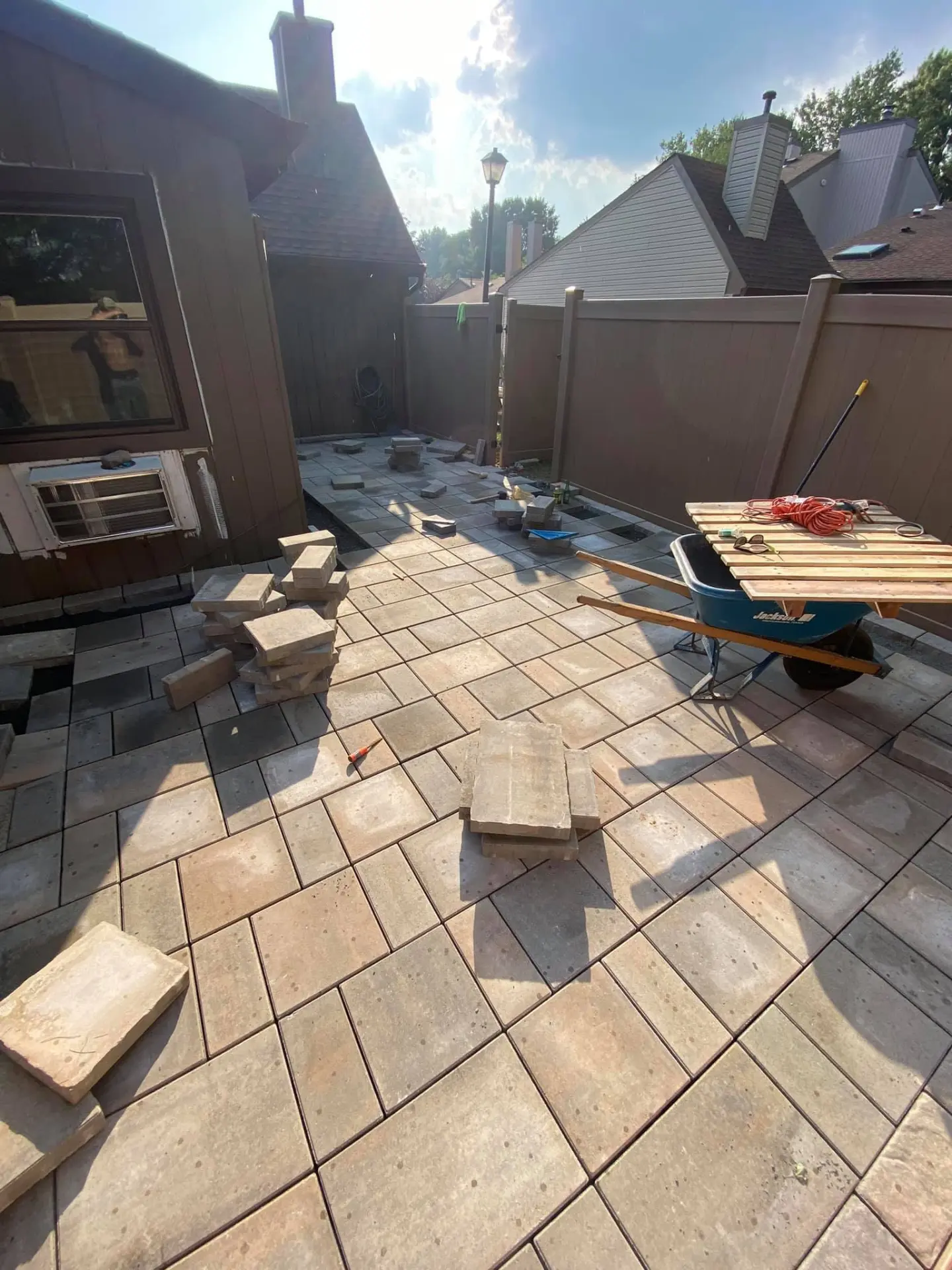 Large paver patio being installed in a backyard by Fiorenza Landscaping
