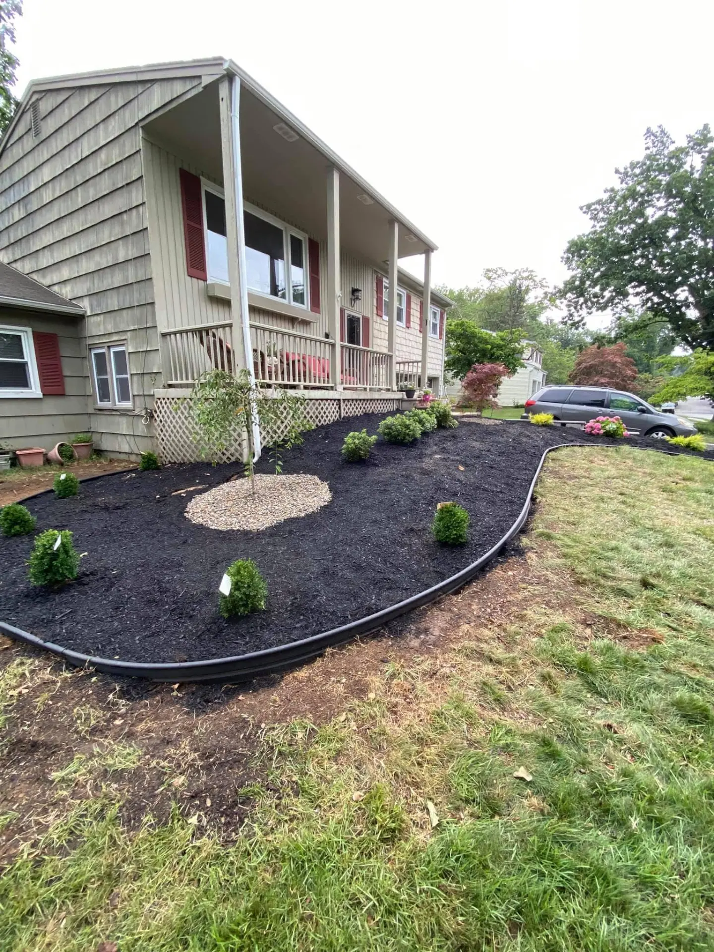 New curved front landscape bed with fresh mulch, shrubs and edging