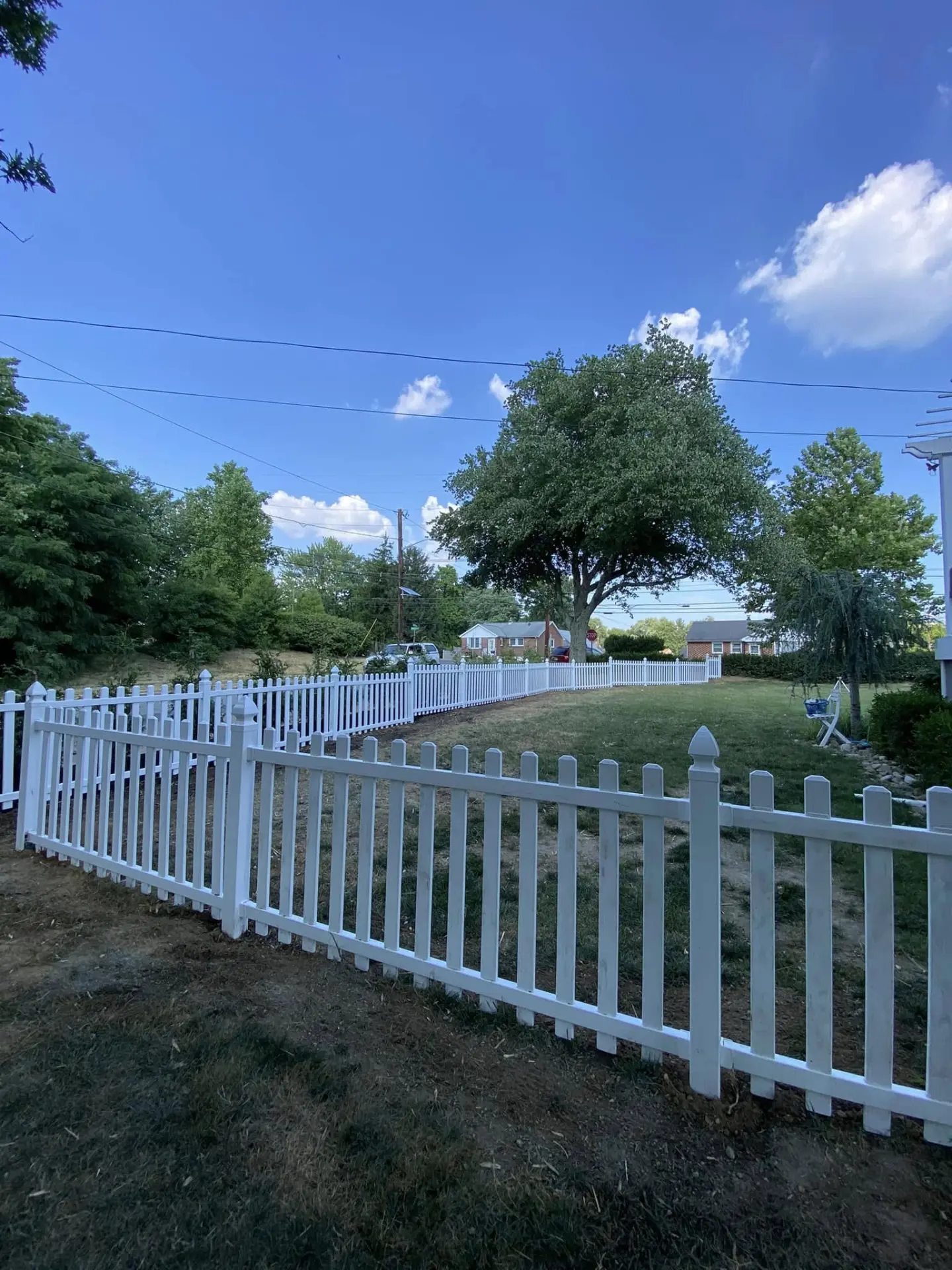 New white picket fence around a freshly graded yard