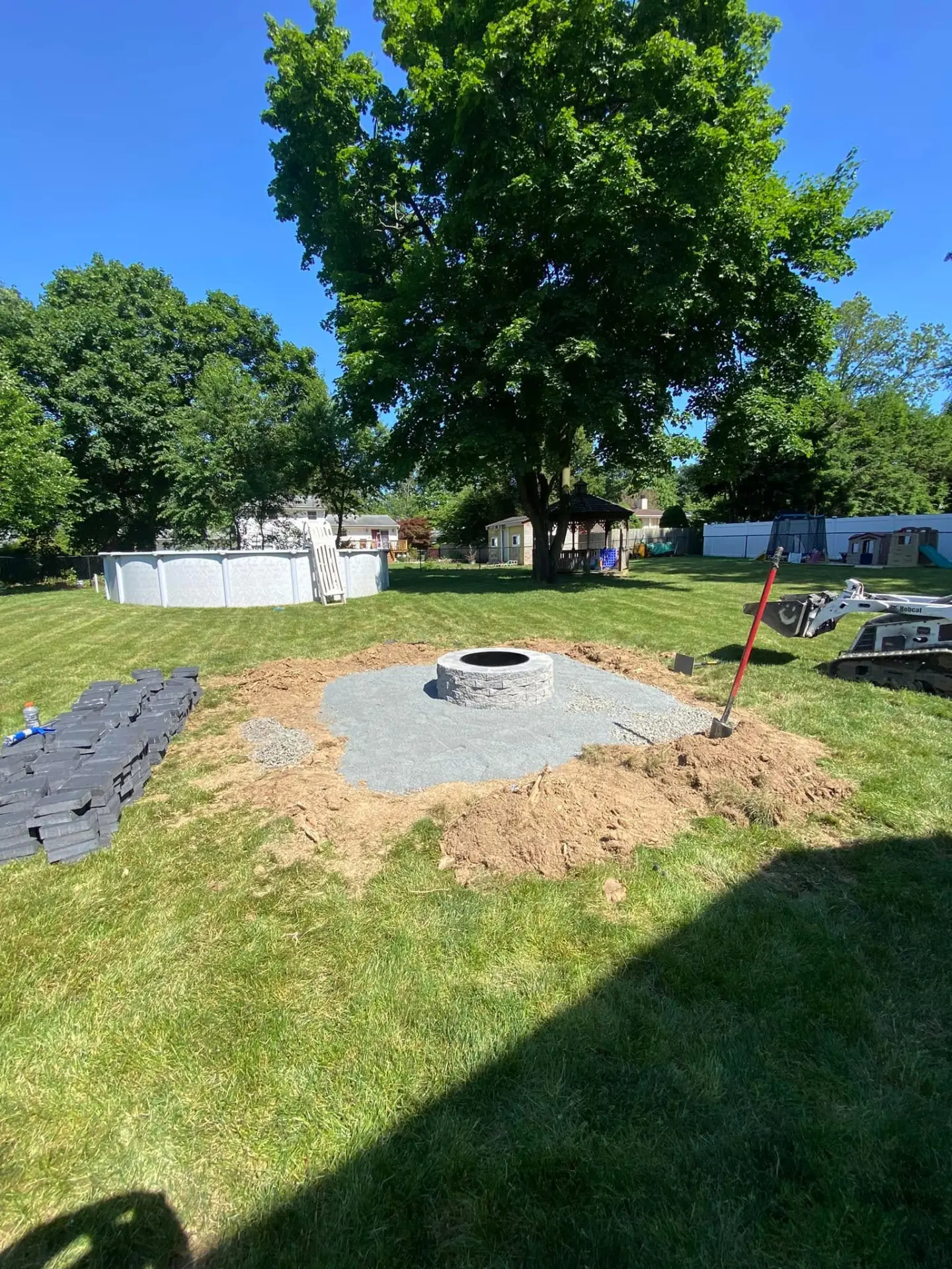 Stone fire pit set on a new gravel base during construction